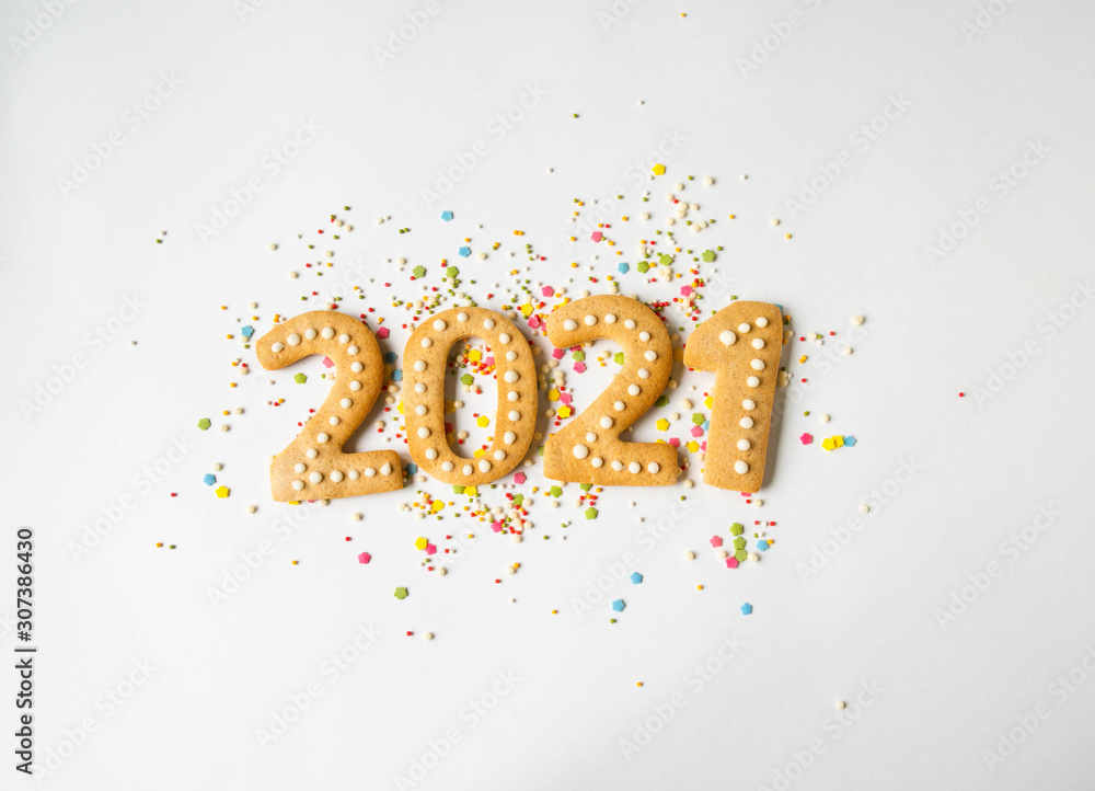 Multi colored pastry sugar topping and gingerbread in the form of numbers 2021 on a white background. 2021 new year ginger cookies Multi colored pastry sugar topping and gingerbread in the form of numbers 2021 on a white background. 2021 new year ginger cookies