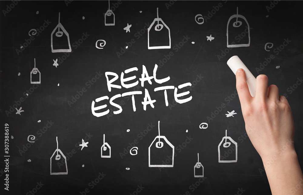 Hand drawing REAL ESTATE inscription with white chalk on blackboard, online shopping concept Hand drawing REAL ESTATE inscription with white chalk on blackboard, online shopping concept