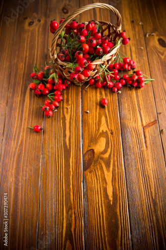 ripe red dogrose in a basket on a wooden