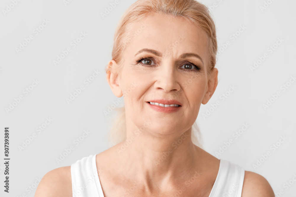 Portrait of beautiful mature woman on light background Portrait of beautiful mature woman on light background