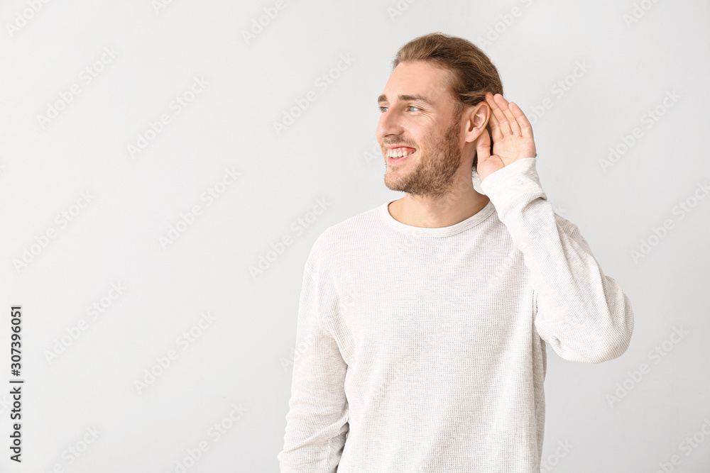 Young man with hearing problem on white background Young man with hearing problem on white background