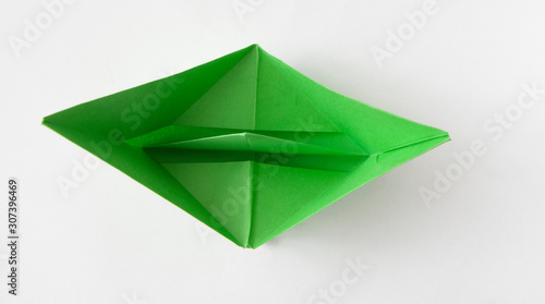 green paper boat on white background