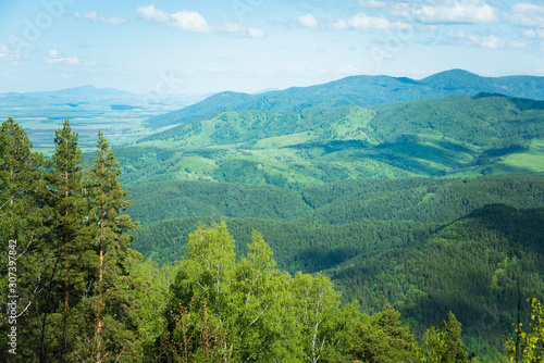 Fototapeta Naklejka Na Ścianę i Meble -  Wooded high mountains extend into the distance in taiga.