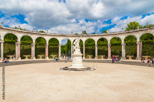 Lovely view of the Colonnade, a circular arched double peristyle in the Gardens of Versailles on a nice summer day. The centre is adorned with the marble statue "The Abduction of Persephone by Pluto".