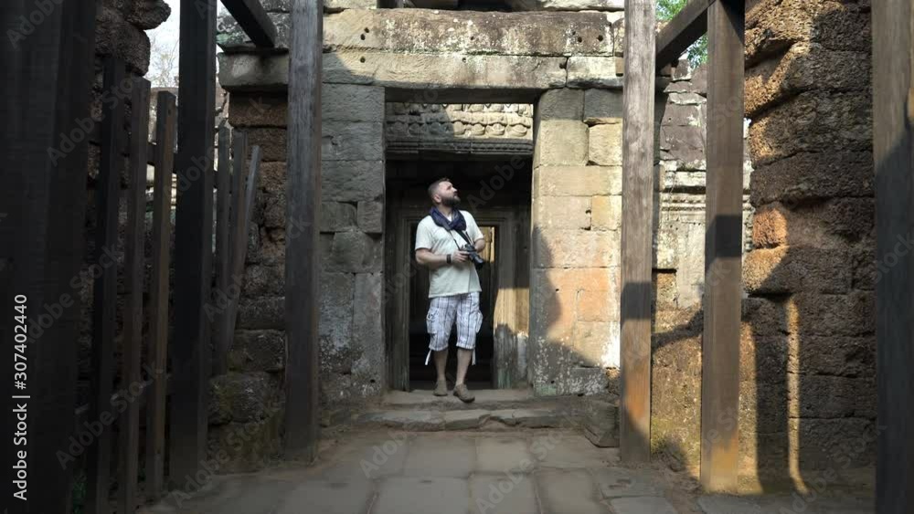 Man admire, sightseeing ancient Angkor Wat complex temple ruins in Cambodia Man admire, sightseeing ancient Angkor Wat complex temple ruins in Cambodia