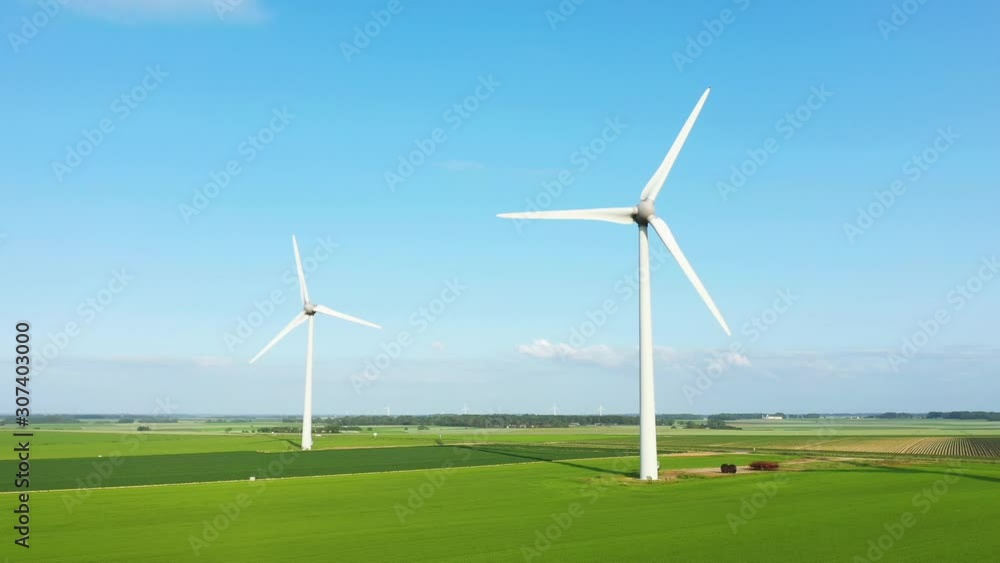 Deux éoliennes dans un champ de lin une journée ensoleillée Deux éoliennes dans un champ de lin une journée ensoleillée