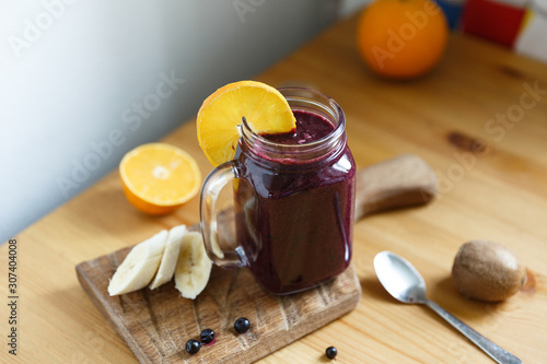 Mason jar mug filled with health smoothie with blackcurrant, blueberry , banana