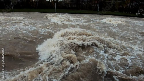 Slow motion tilt up flooded rapid chaotic river in Tacen, Slovenia photo