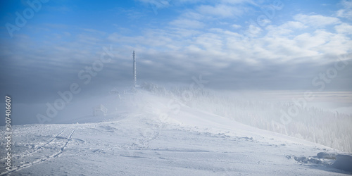 Frozen cellular tower. Frozen telecommunication towers with dish and mobile antenna against blue sky in winter mountains. © Roman Pyshchyk