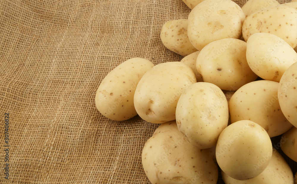 Heap of raw young potatoes on burlap background Heap of raw young potatoes on burlap background