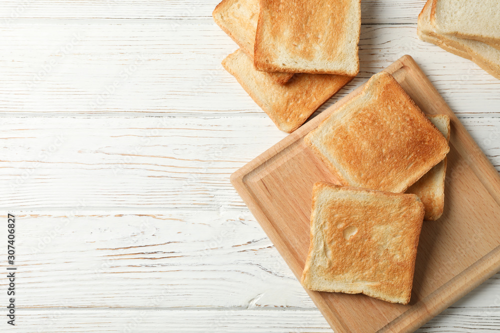 Board with toasts on white wooden background, space for text Board with toasts on white wooden background, space for text