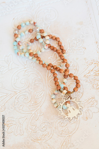 Jewelry mala necklace with natural mineral beads on white wooden decorative background