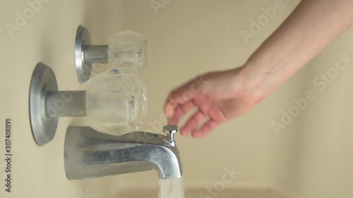 Hand Turns on Water to Test for Heat 60fps