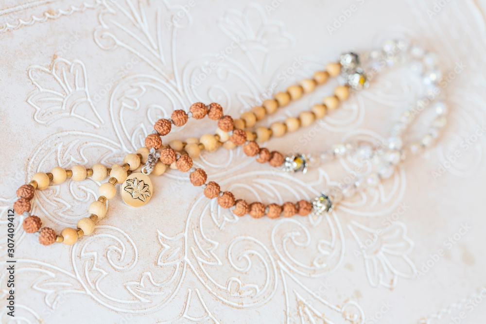 Jewelry mala necklace with natural mineral beads on white wooden decorative background Jewelry mala necklace with natural mineral beads on white wooden decorative background