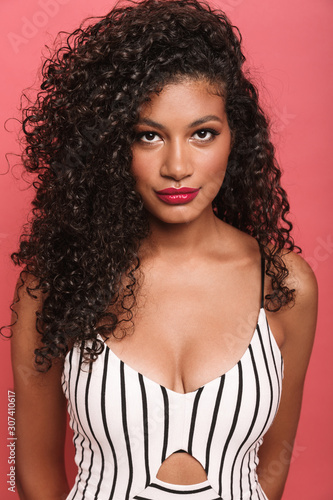 Image of pretty african american woman with curly hair looking at camera