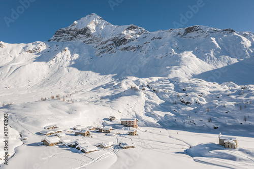 Little village covered with snow in mountain. Valmalenco, Prabello.  Winter in Italian Alps photo