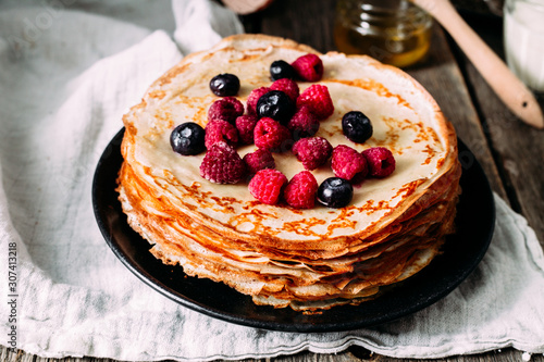 Pancakes on a plate with berries. Breakfast. Maslenitsa