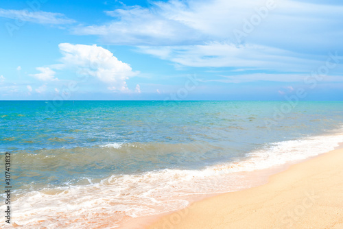Ocean wave on tropical beach with golden sand and ripple of water splash from emerald blue-green sea water during summer vacation. 