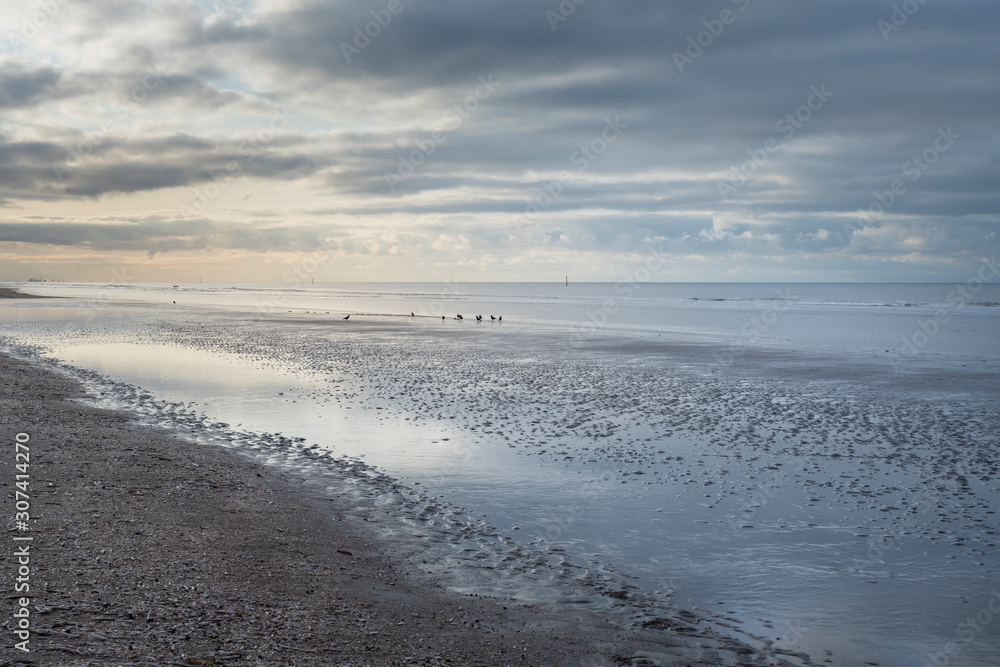 Nieuwpoort, Belgium - November 14,02019: soft colored cloudy seascape with blues oranges