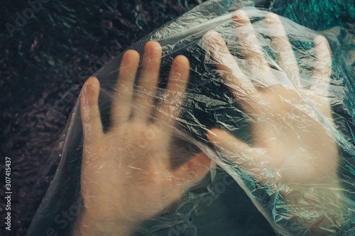 Beautiful abstract plastic cellophane  bag background. Human hand shows palm help stop.  No Plastic Bag Concept, save world, protect earth. photo