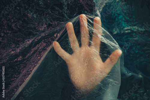 Beautiful abstract plastic cellophane  bag background. Human hand shows palm help stop.  No Plastic Bag Concept, save world, protect earth. photo