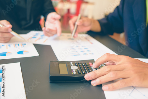 Businessman analysis on Graph data paper using calculator, finance concept in office.