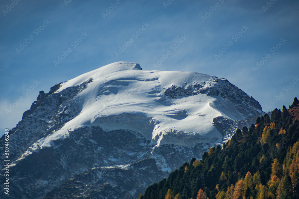 The Swiss mountains in the Engadine with woods, glaciers, near the village of Pontresina, Switzerland - October 2019.