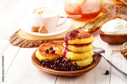 Cottage cheese pancakes and blueberries on a white wooden table, selective focus