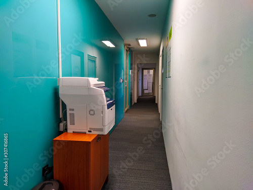 Modern hallway at work office job with laser printer available for workers for doing the paperwork and dealing with copying documents