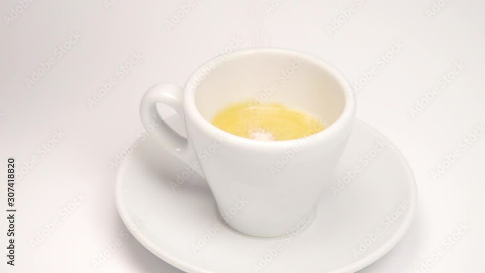 pouring sugar into a rotating cup of coffee isolated on white background pouring sugar into a rotating cup of coffee isolated on white background