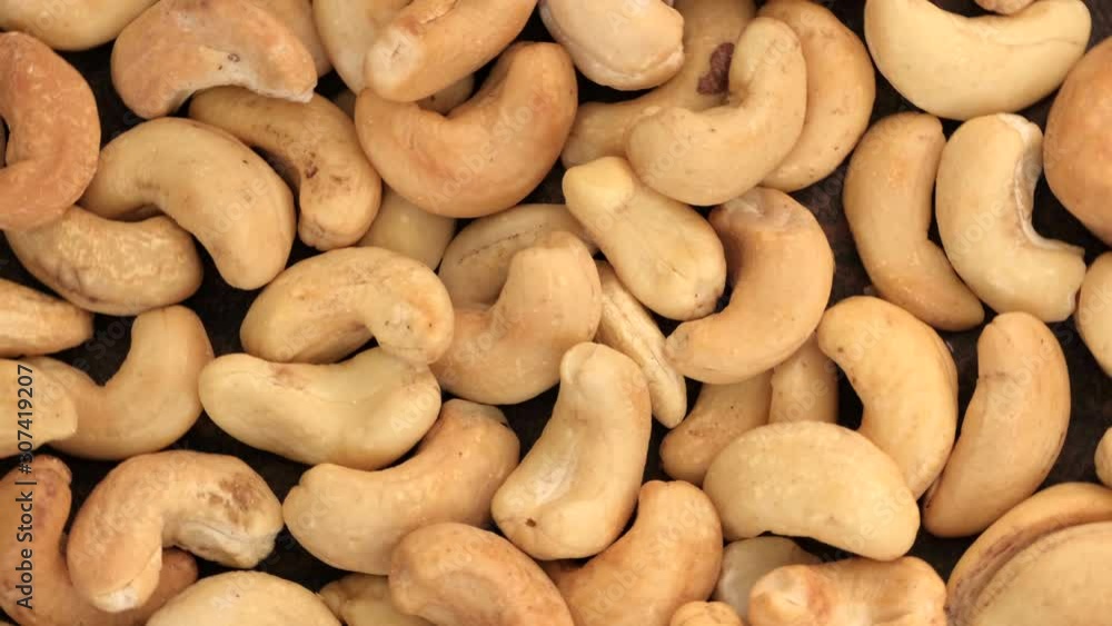 Grocery video screen saver, rotating background of roasted cashew nuts close-up top view Grocery video screen saver, rotating background of roasted cashew nuts close-up top view