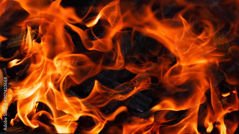Texture of a flame of fire on a black background. burning fire in a stove closeup Texture of a flame of fire on a black background. burning fire in a stove closeup