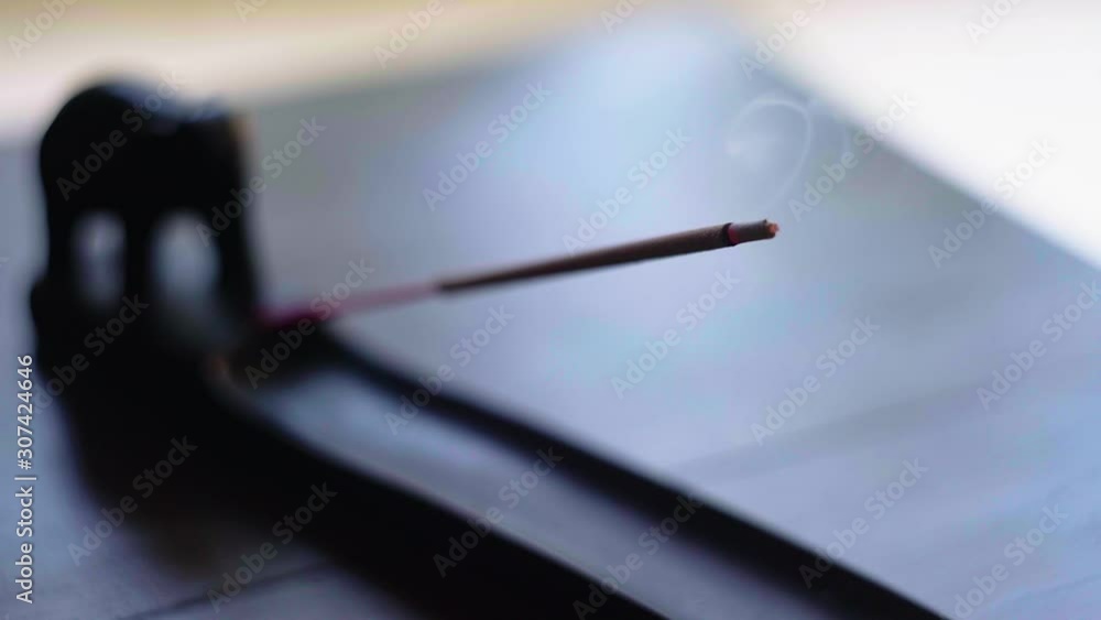 Incense stick burning in holder close up shot. Close up of elephant shaped incense burner with burning stick Incense stick burning in holder close up shot. Close up of elephant shaped incense burner with burning stick