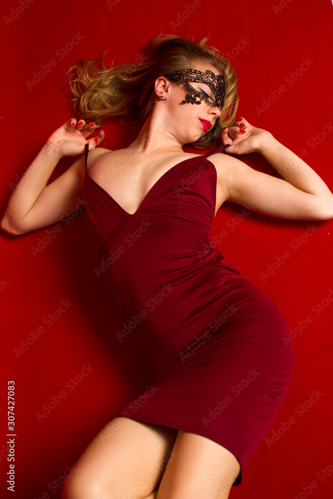 Dynamic shot of a young beautiful sexy woman in a red dress dancing on a red background Dynamic shot of a young beautiful sexy woman in a red dress dancing on a red background