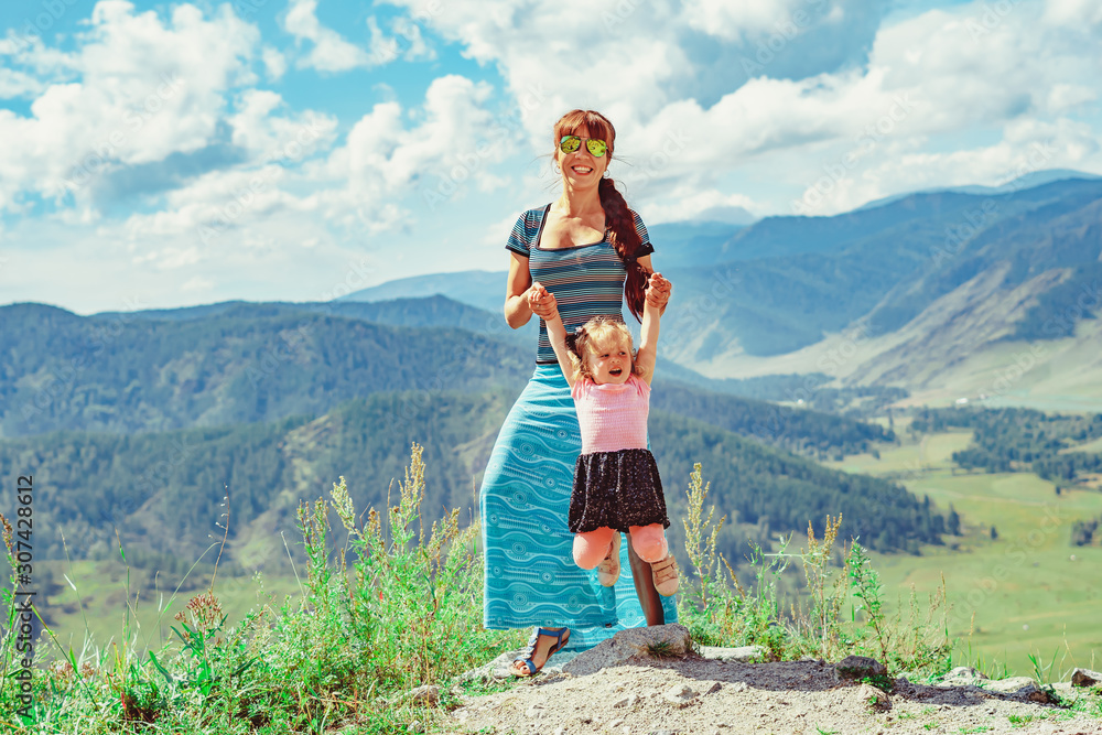 Fototapeta premium mother and daughter standing on the background of mountains
