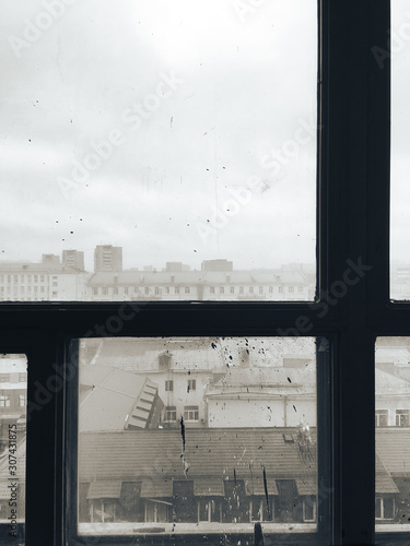 view of the city through the old wooden window frames