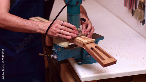 Guitar maker makes a hole for guitar truss rod