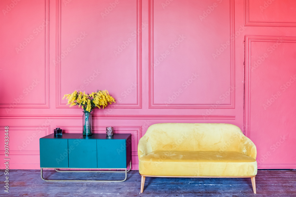 Bright color interior. Pink wall, yellow sofa and blue bedside table with  flowers. Stock Photo | Adobe Stock