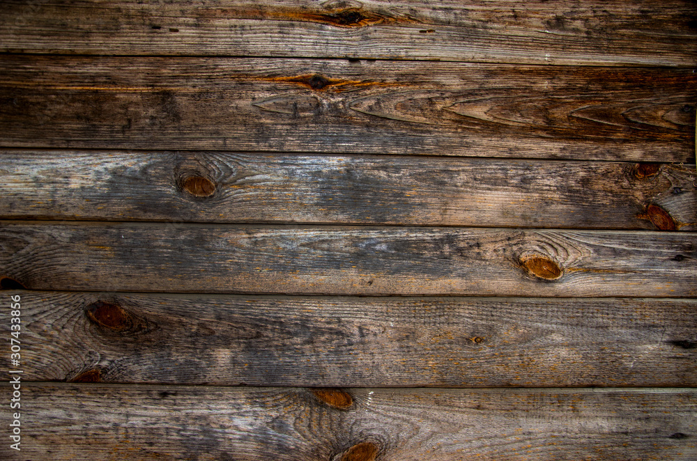 Old pine horizontal boards. The wood texture is brown-gray with rings from knots and scuffs. Abstract wooden background. Old pine horizontal boards. The wood texture is brown-gray with rings from knots and scuffs. Abstract wooden background.