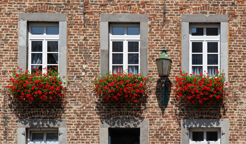 Photos detail of brick house with beautiful red flower boxes outside in Aachen, Germany