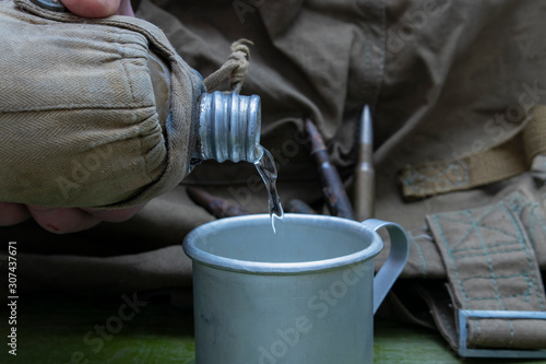 World War II. Old military flask, mug, rusty cartridges and travel bag.