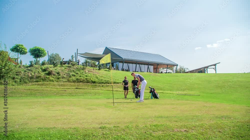 Young golfer celebrated after he hits the ball in the hole, enjoying time with friends Young golfer celebrated after he hits the ball in the hole, enjoying time with friends