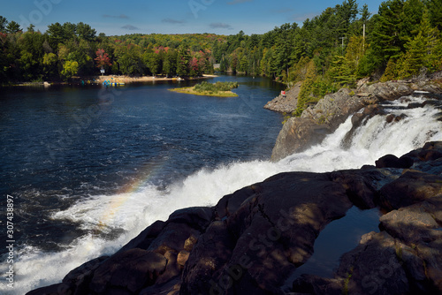 Water spray with rainbow on the north Muskoka river at High Falls with cottage beaches photo