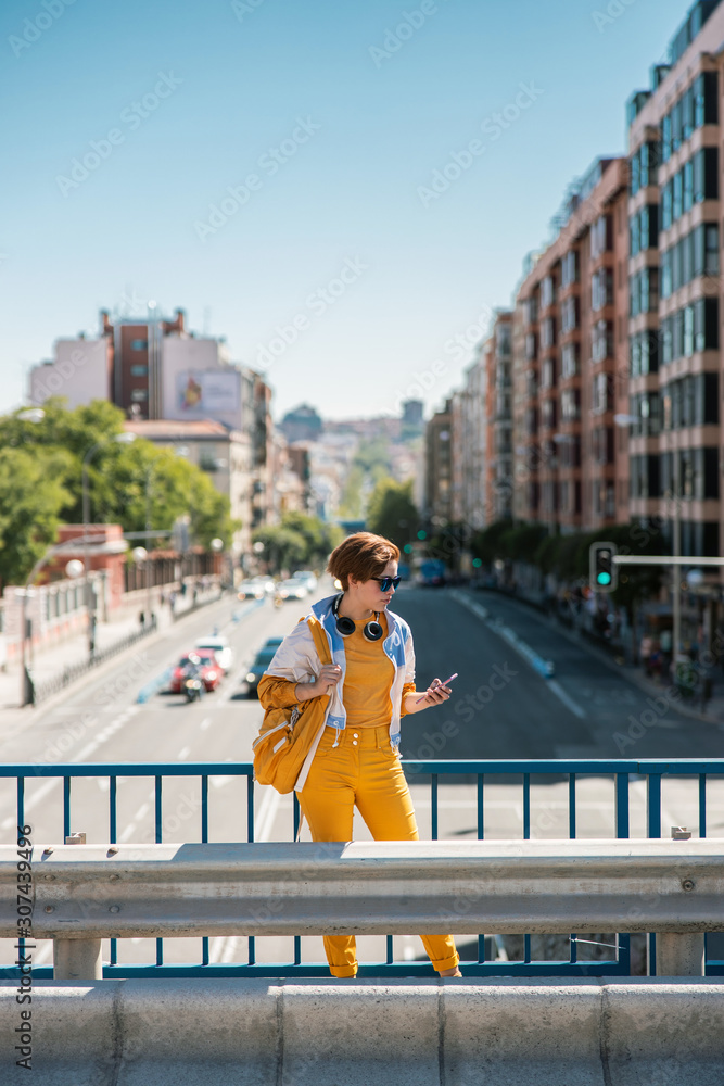 Woman standing on road bridge and looking at mobile phone Woman standing on road bridge and looking at mobile phone
