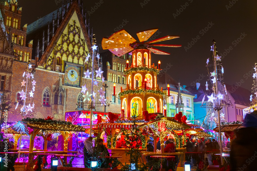 Advent in Wroclaw, Poland. Main Christmas Square in Wroclaw, Polish old city. Christmas time in Europe background. Christmas Markets in December. Blurred people amusing by street food stalls.