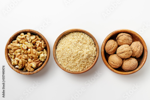 Whole walnuts, walnut kernel and ground walnuts in wooden bowls . photo