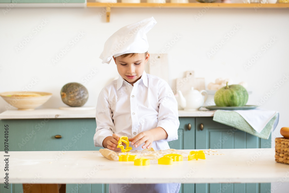 child boy in the cook costume baking cookies child boy in the cook costume baking cookies