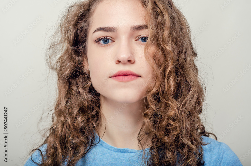 Portrait of beautiful young girl, close-up. Curly hair. Playing hair Portrait of beautiful young girl, close-up. Curly hair. Playing hair