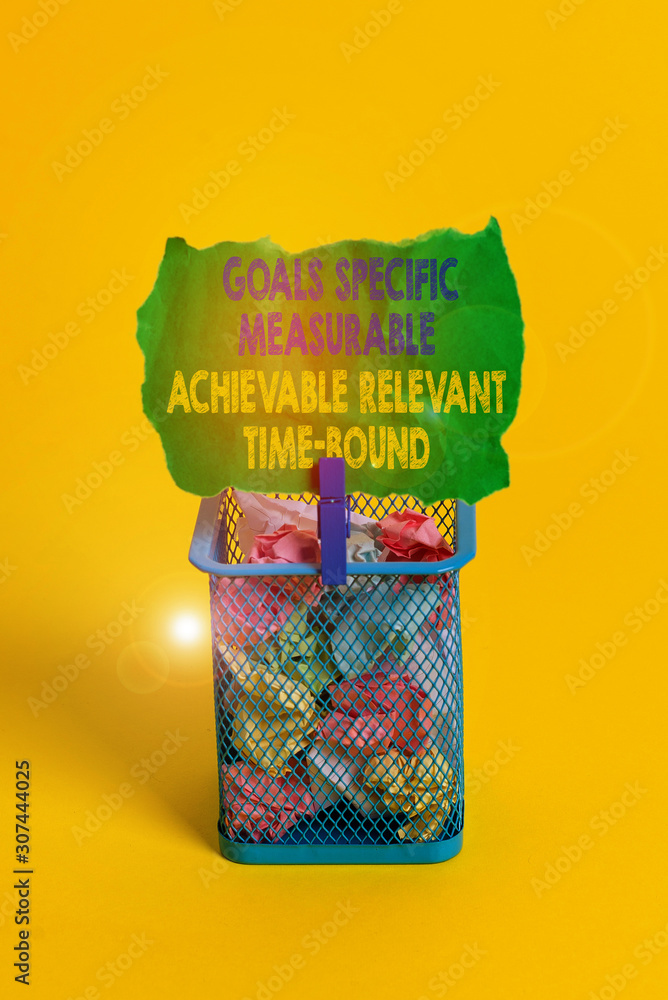 Obraz premium Word writing text Goals Specif Measureable AC. Business photo showcasing Goals Specific Measurable Achievable Relevant Time Bound Trash bin crumpled paper clothespin empty reminder office supplies