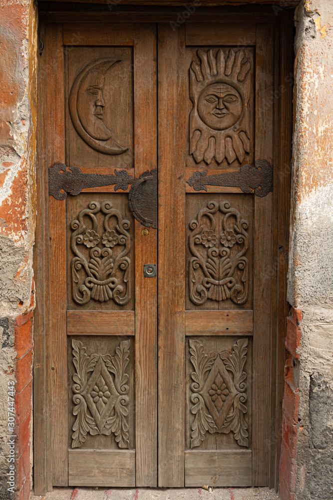 Puerta de madera vintage con grabados y herrajes oxidados 